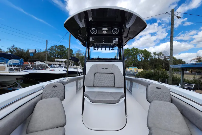 Slide: The Image of 2022 Sea Pro 259 Deep V CC boat interior with seating and canopy under blue sky. - 19