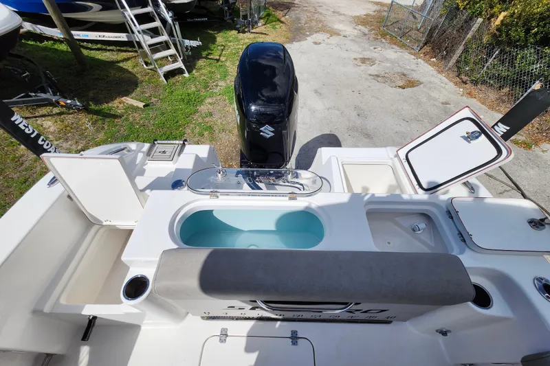 Slide: The Image of 2022 Sea Pro 259 Deep V CC boat with Suzuki outboard motor and open storage compartments. - 34