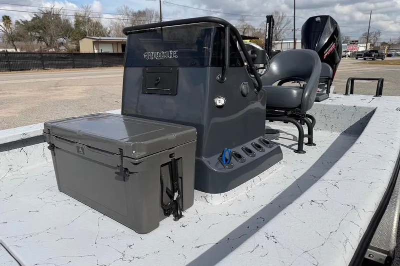 Slide: The Image of 2025 Haynie 23 Magnum boat interior with console and seating, featuring a gray cooler. - 8