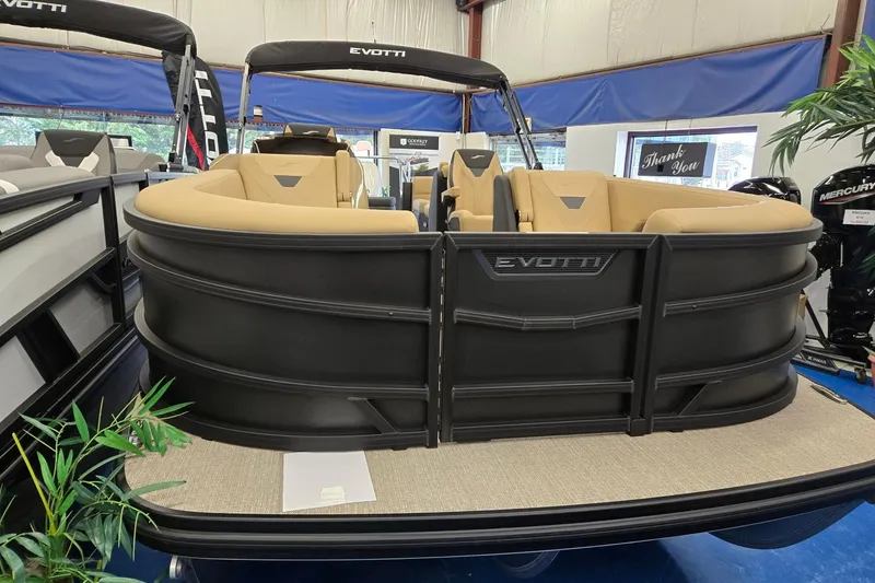 Slide: The Image of 2026 Evotti 521QL pontoon boat with tan seating, displayed indoors. - 0