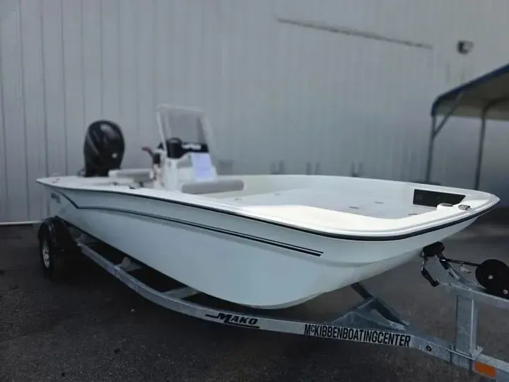 Slide: The Image of 2026 Mako Pro Skiff 17 CC on trailer outside building. - 8