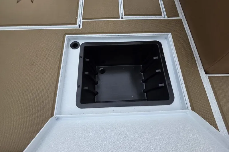 Slide: The Image of 2026 Xpress H20CC boat storage compartment with tan and white interior. - 10