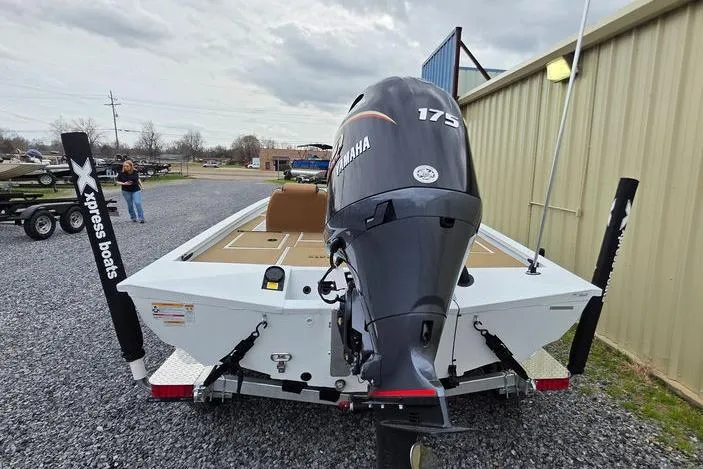 Slide: The Image of 2026 Xpress H20CC boat with Yamaha 175 engine, parked on gravel near a building. - 11