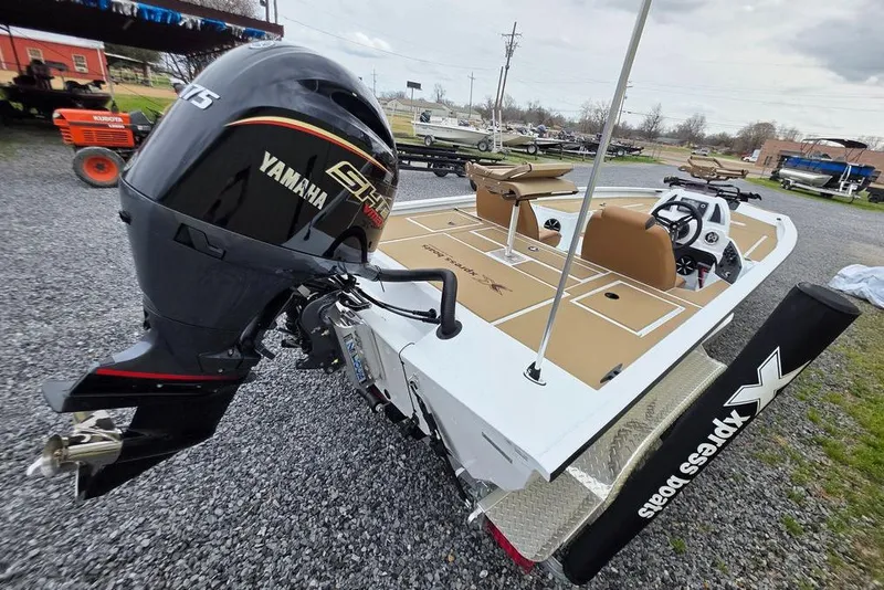 Slide: The Image of 2026 Xpress H20CC boat with Yamaha engine, parked on gravel, showcasing sleek design. - 13