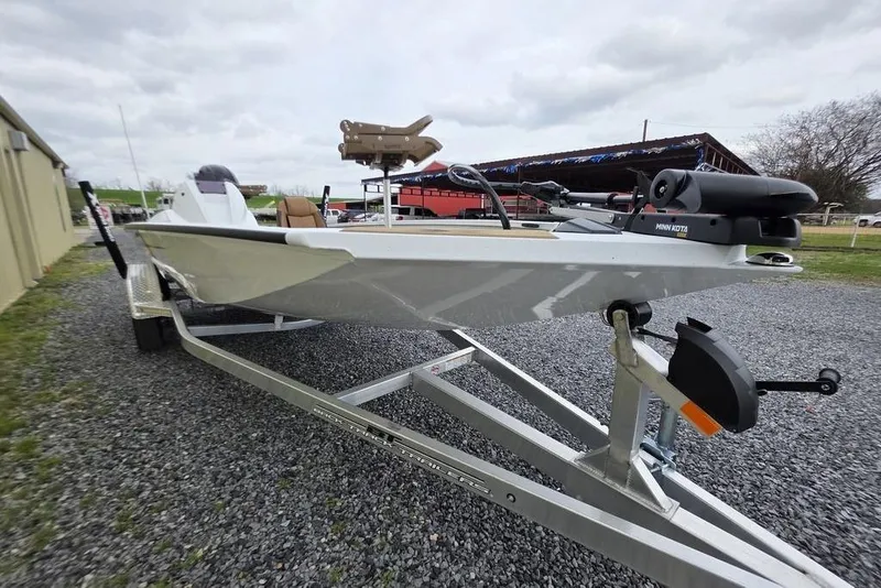 Slide: The Image of 2026 Xpress H20CC boat on trailer, featuring Minn Kota trolling motor, parked outdoors. - 18