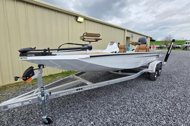 Slide: The Image of 2026 Xpress H20CC boat on trailer, parked outside a building under cloudy skies. - 3