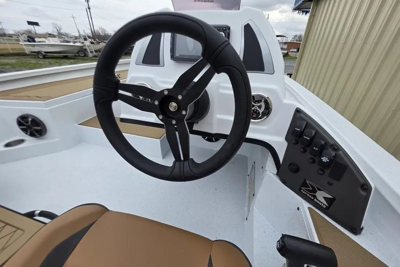 Slide: The Image of Steering console of 2026 Xpress H20CC boat with modern controls and comfortable seating. - 9