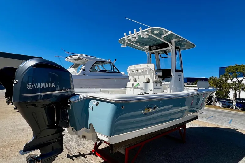 Slide: The Image of 2021 Sea Hunt BX 25 FS boat with Yamaha engine, displayed outdoors under clear blue sky. - 14