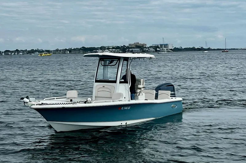 Slide: The Image of 2021 Sea Hunt BX 25 FS boat on calm water with distant shoreline. - 6