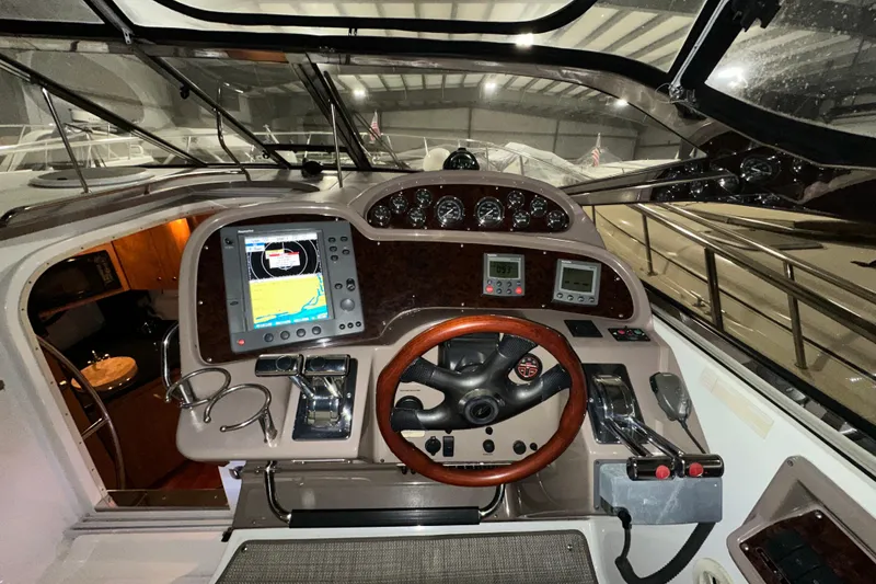 Slide: The Image of 2004 Regal Commodore 3860 yacht cockpit with navigation equipment and wooden steering wheel. - 10
