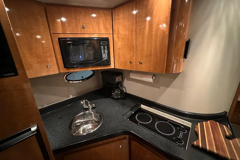 Slide: The Image of 2004 Regal Commodore 3860 yacht kitchen with microwave, sink, and stovetop. - 15