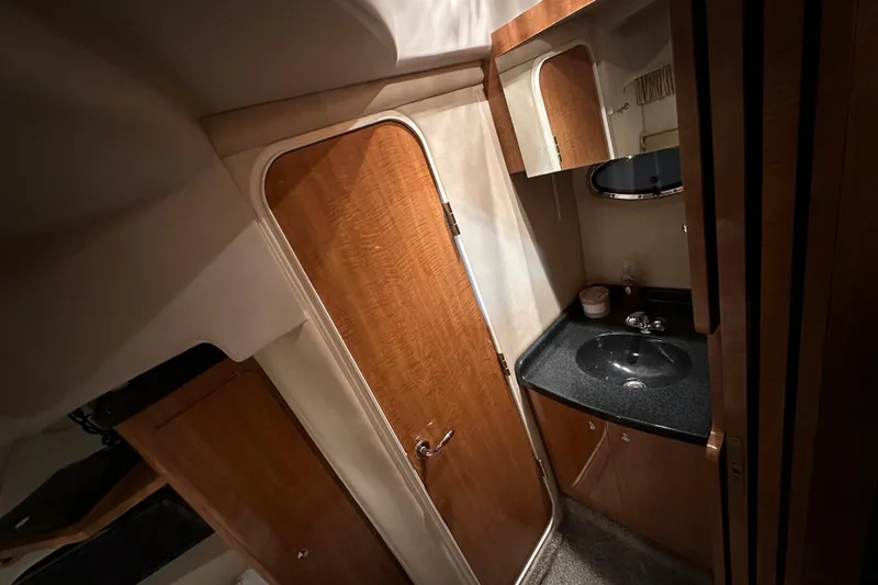 Slide: The Image of Interior of 2004 Regal Commodore 3860 yacht bathroom with wooden cabinetry and black countertop. - 22