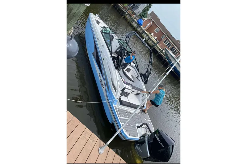 Slide: The Image of 2021 Monterey Boats M65 docked with two people onboard, featuring a sleek design. - 3