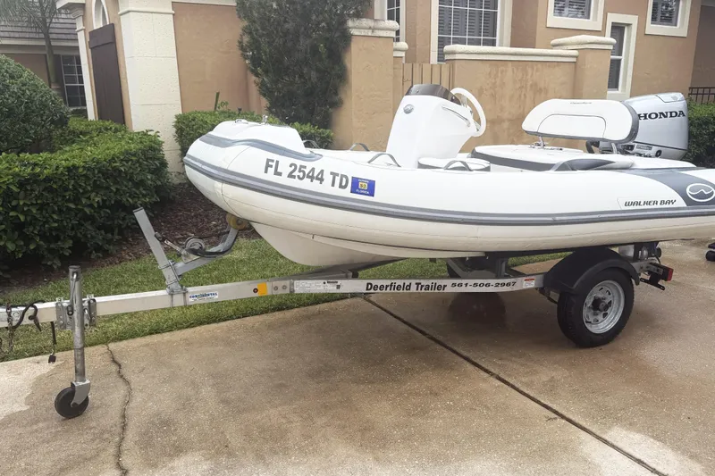 The Image of 2022 Walker Bay Generation 11 LTE boat on trailer, parked in residential driveway. - 0