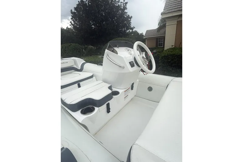 Slide: The Image of 2022 Walker Bay Generation 11 LTE boat interior with white seating and steering wheel. - 3
