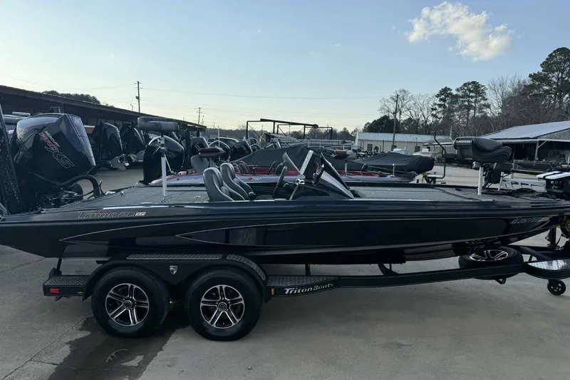 Slide: The Image of 2024 Triton 20XP Patriot boat on trailer, parked outdoors at a dealership. - 11