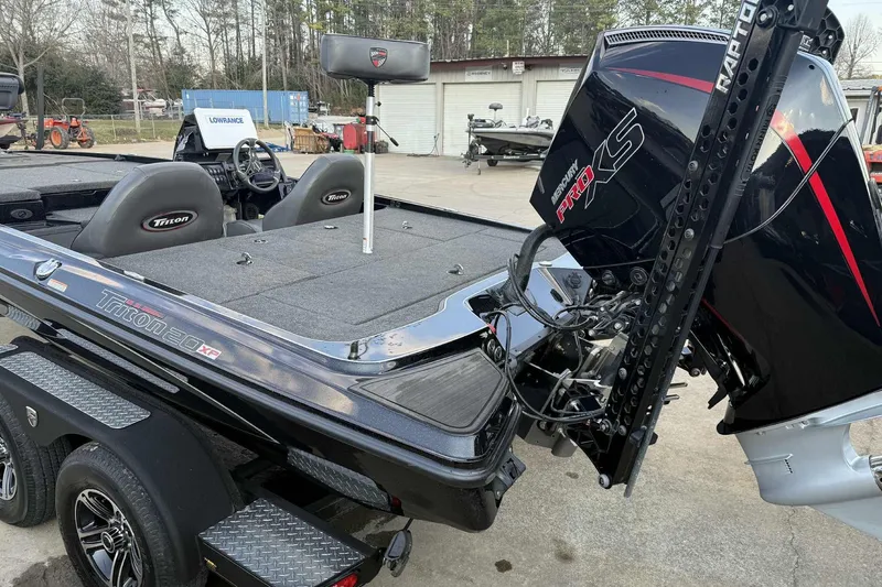 Slide: The Image of 2024 Triton 20XP Patriot boat with Mercury Pro XS engine, parked outdoors. - 8
