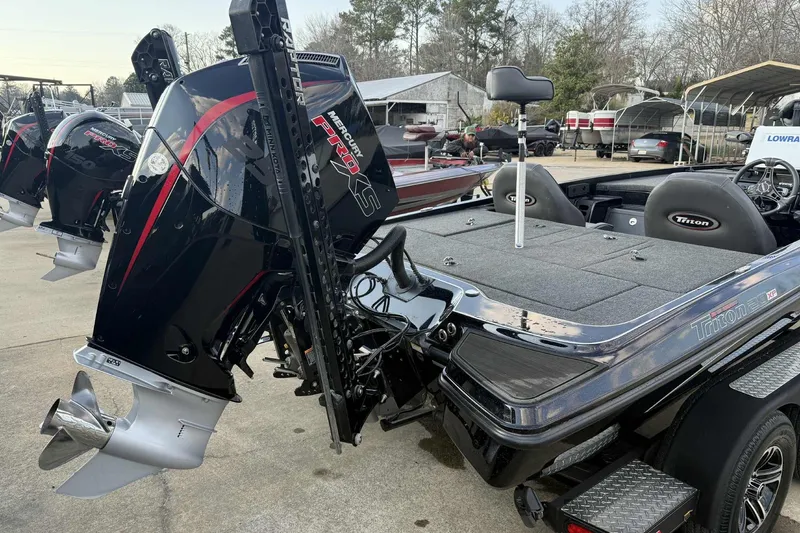 Slide: The Image of 2024 Triton 20XP Patriot boat with Mercury Pro XS engine, parked outdoors. - 9