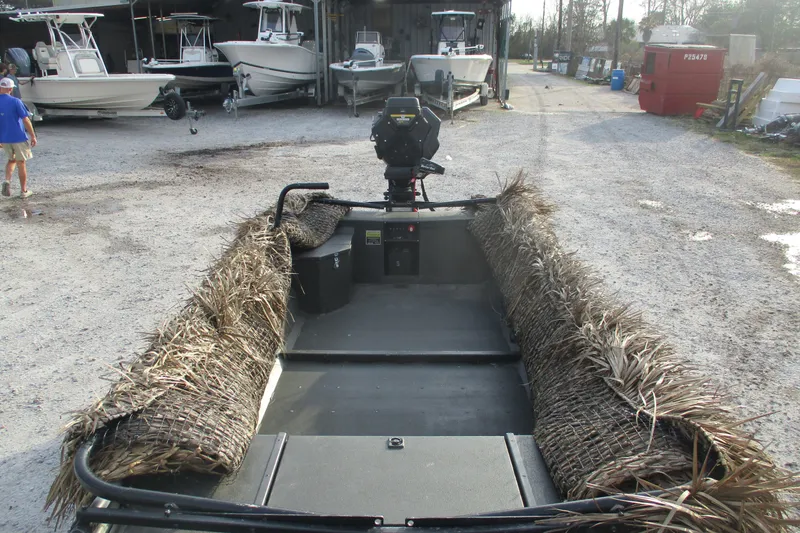 Slide: The Image of 2026 Gator Tail 1748 GATOR boat with camouflage, parked near other boats. - 3