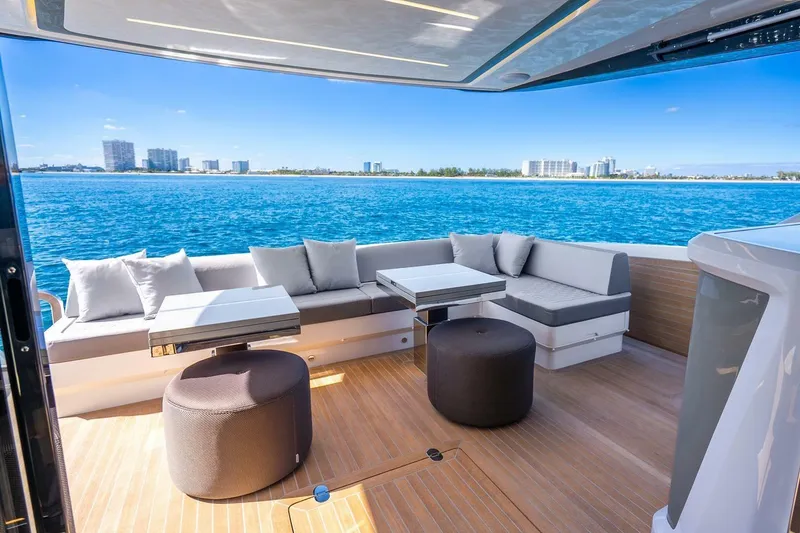Slide: The Image of Luxurious Pearl 63 yacht deck with modern seating, ocean view, and city skyline, 2025 model. - 62