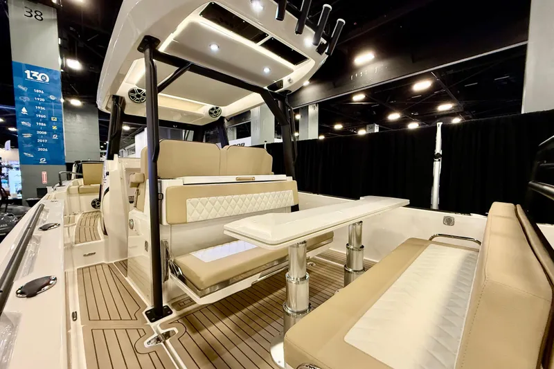 Slide: The Image of 2026 Zodiac X9CC boat interior with beige seating and modern design at a showroom. - 8