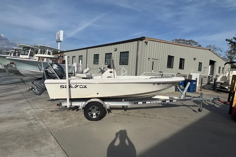 Slide: The Image of 2005 Sea Fox 160 Center Console boat on trailer, parked outside a building. - 1