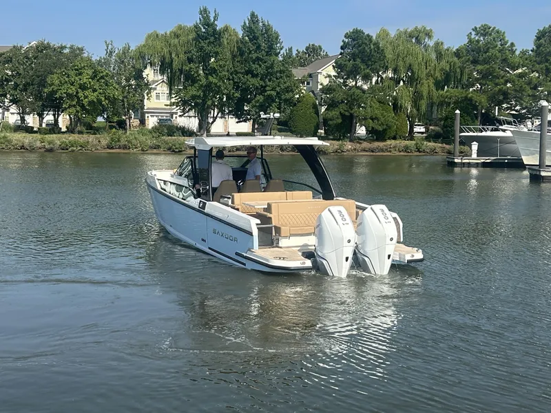 Slide: The Image of A 2027 Saxdor 320 GTO cruising on calm waters. Two outboard engines are visible. - 3
