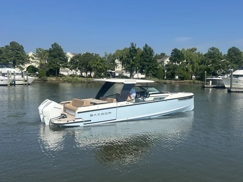 Slide: The Image of Saxdor 320 GTO 2027 on calm water with sleek lines and twin outboard engines. - 1