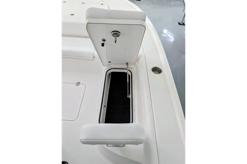 Slide: The Image of 2026 Caymas 26 HB boat storage compartment with open hatch and cushioned seat. - 11