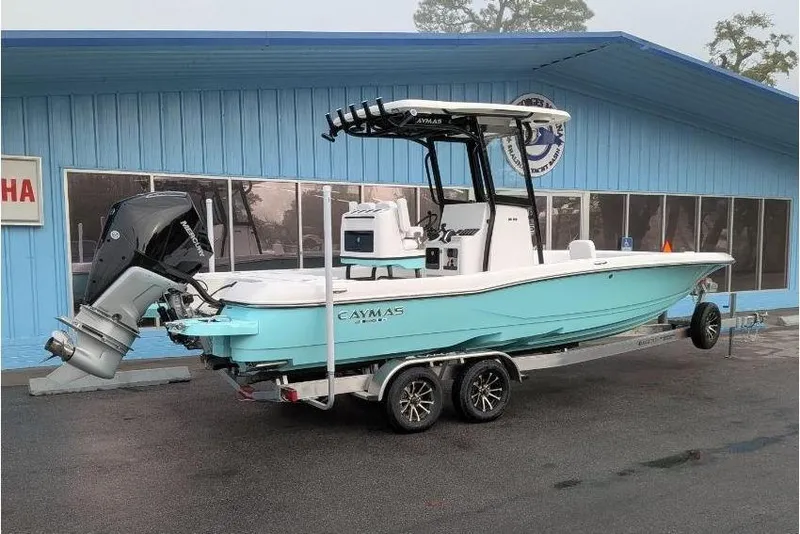 Slide: The Image of 2026 Caymas 26 HB boat on trailer in front of blue building. - 3