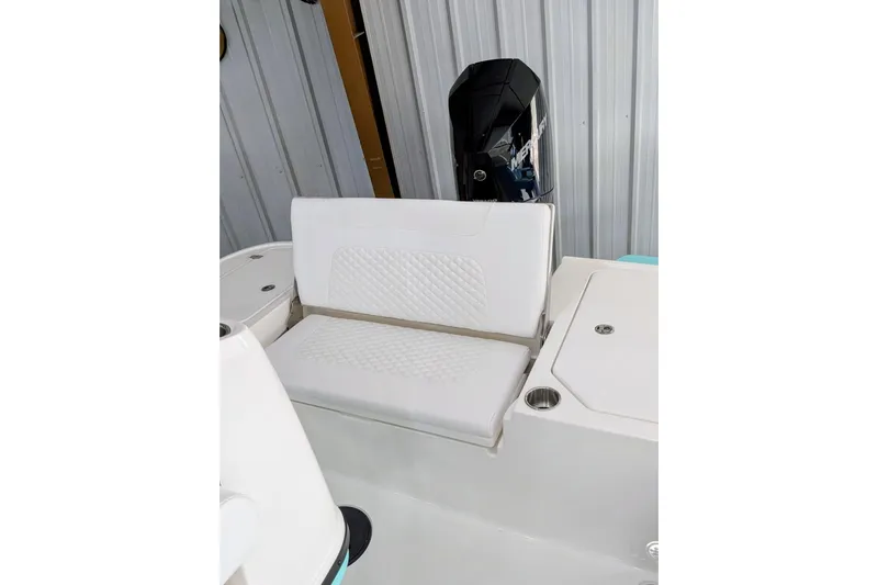 Slide: The Image of 2026 Caymas 26 HB boat interior with white cushioned seating and outboard motor. - 8
