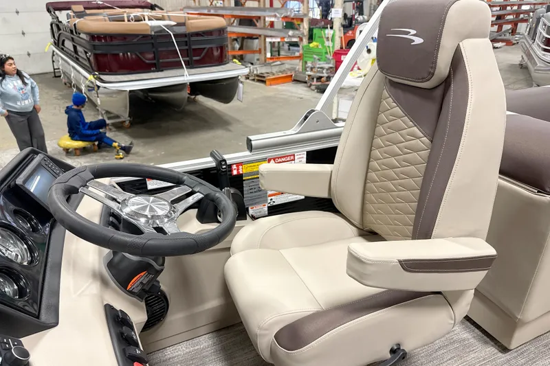 Slide: The Image of Captain's chair and steering wheel of 2026 Bennington 22 SSR pontoon boat in a showroom. - 9