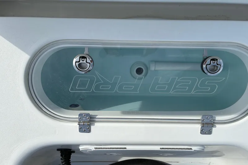 Slide: The Image of 2026 Sea Pro 250 Bay boat livewell with clear lid and secure latches. - 20