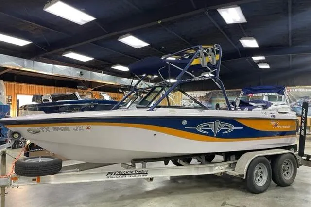 The Image of 2003 Nautique Super Air Nautique 210 boat on trailer in showroom. - 1