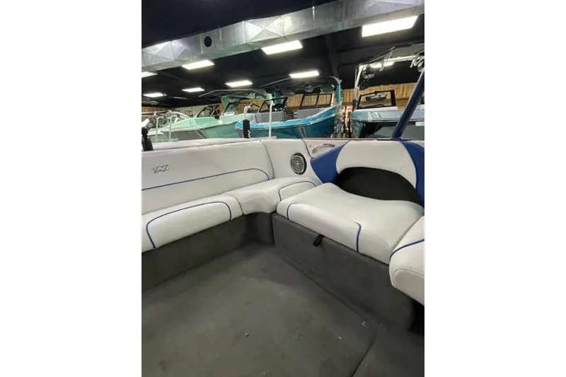 Slide: The Image of 2003 Nautique Super Air Nautique 210 interior with white and blue seating. - 3
