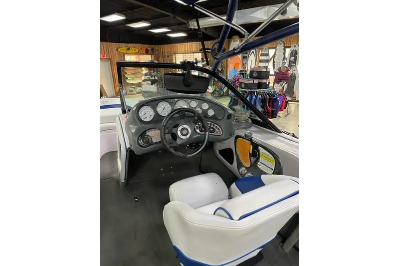 Slide: The Image of 2003 Nautique Super Air Nautique 210 boat dashboard with steering wheel and gauges. - 4