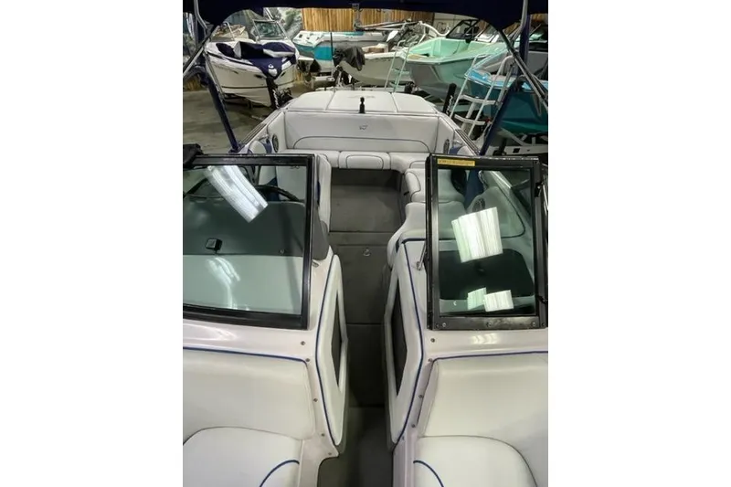 Slide: The Image of 2003 Nautique Super Air Nautique 210 boat interior with white seating and glass windshields. - 7