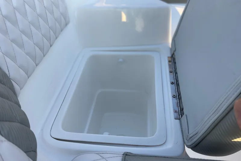 Slide: The Image of Open storage compartment in 2026 Caribe DL12 boat with quilted seating. - 7