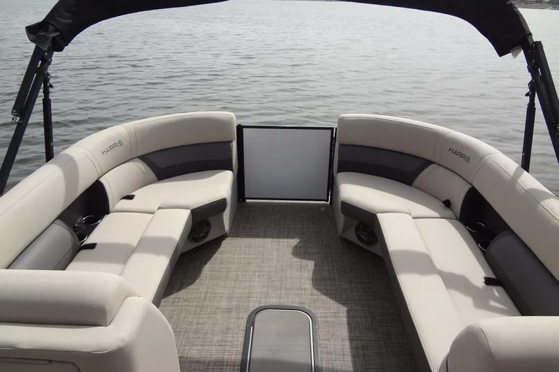 Slide: The Image of 2022 Harris FloteBote 230 Cruiser interior with plush seating on calm water. - 13
