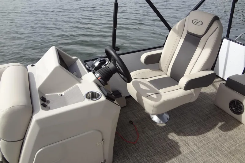 Slide: The Image of 2022 Harris FloteBote 230 Cruiser helm with beige captain's chair and steering wheel. - 18