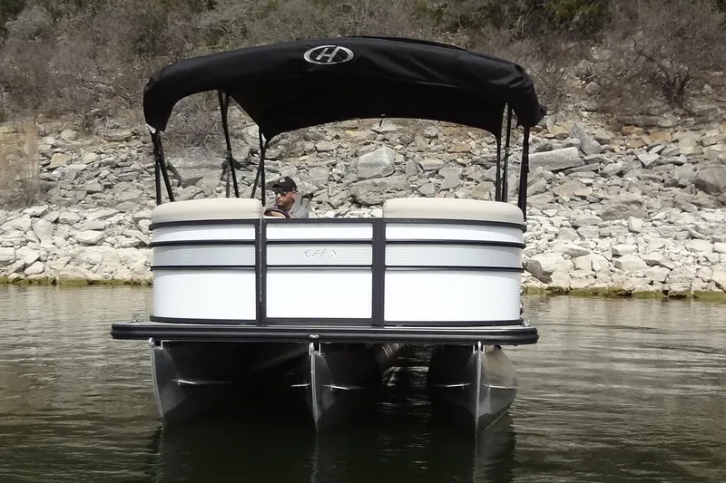 Slide: The Image of 2022 Harris FloteBote 230 Cruiser pontoon boat on calm water near rocky shore. - 3