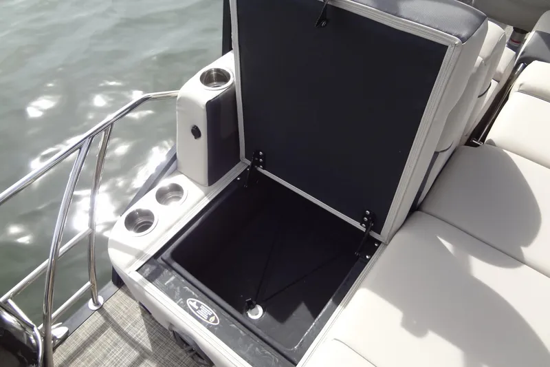 Slide: The Image of 2022 Harris FloteBote 230 Cruiser storage compartment with cup holders on a sunny day. - 30