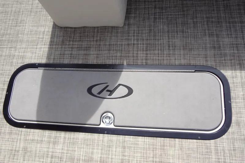 Slide: The Image of Harris FloteBote 230 Cruiser 2022 floor compartment with logo on textured surface. - 33