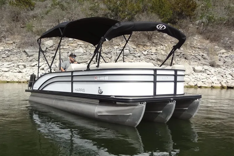 Slide: The Image of 2022 Harris FloteBote 230 Cruiser pontoon boat on calm water near rocky shoreline. - 4