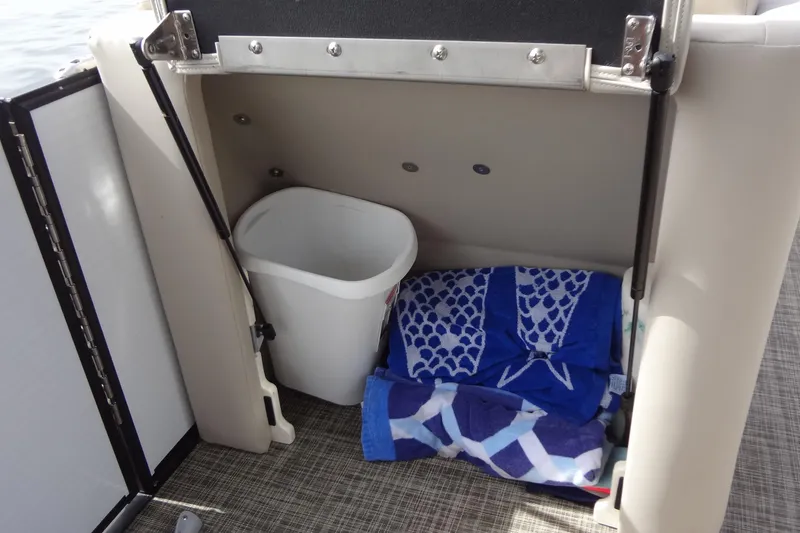 Slide: The Image of Storage compartment in 2022 Harris FloteBote 230 Cruiser with towels and a trash bin. - 40
