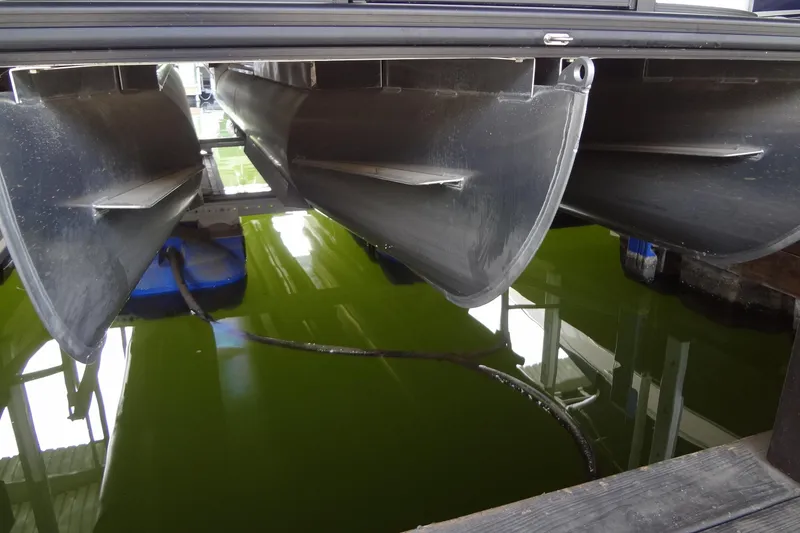 Slide: The Image of 2022 Harris FloteBote 230 Cruiser pontoons above green water in a dock. - 44