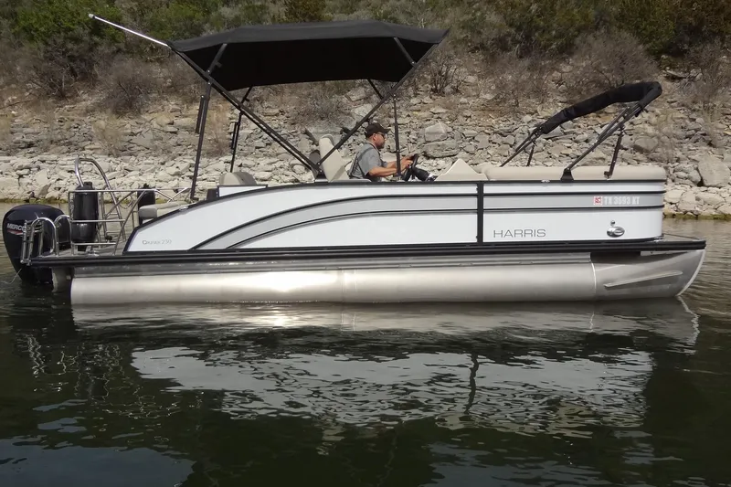 Slide: The Image of 2022 Harris FloteBote 230 Cruiser pontoon boat on calm water near rocky shoreline. - 6
