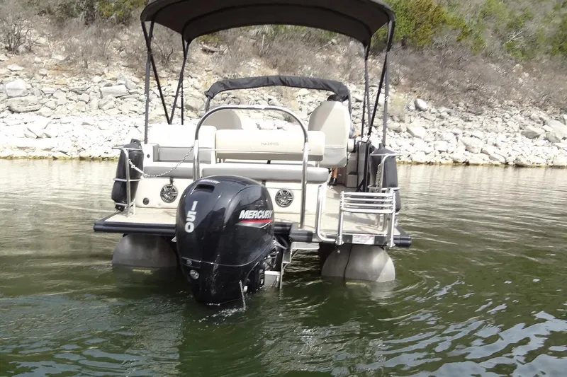 Slide: The Image of 2022 Harris FloteBote 230 Cruiser pontoon boat with Mercury 150 engine on a calm lake. - 8