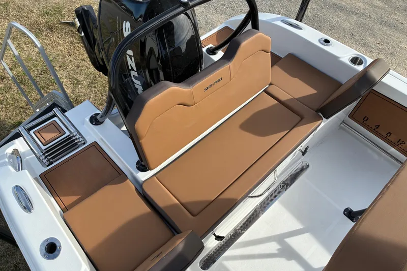 Slide: The Image of 2026 Sea Pro 225FLX Sandbar boat interior with tan seating and Suzuki engine. - 7