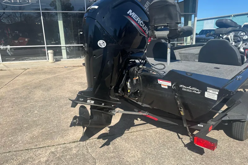 Slide: The Image of 2024 Tracker Pro Team 175 TXW boat with Mercury outboard motor, parked outdoors. - 10